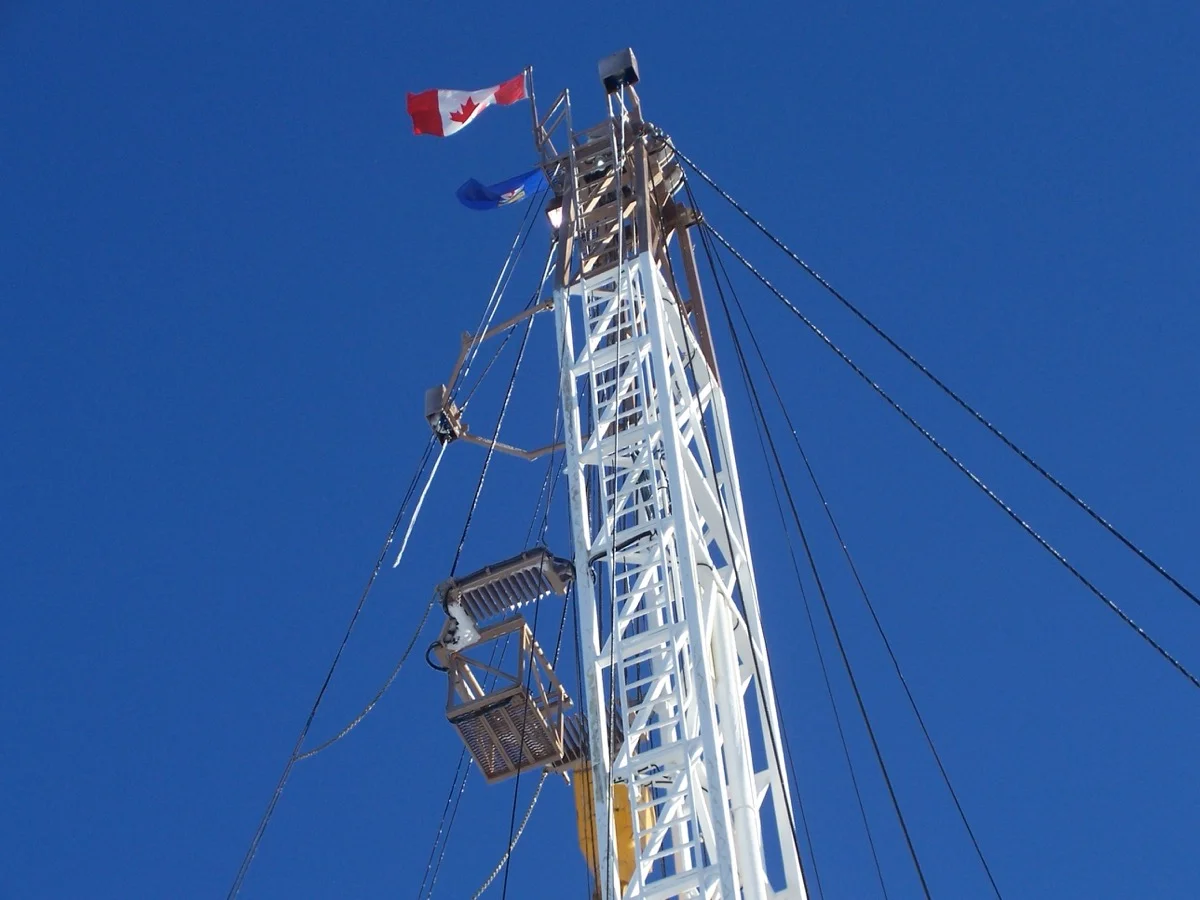 A Canadian flag proudly flown at the top of a rig derrick